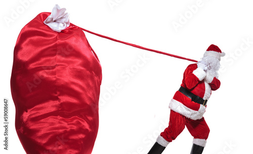 santa claus is pulling a huge bag of presents