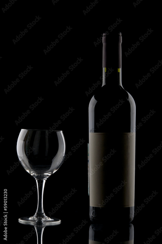 Wine bottle and goblet on black backdrop Wine bottle and goblet on black backdrop