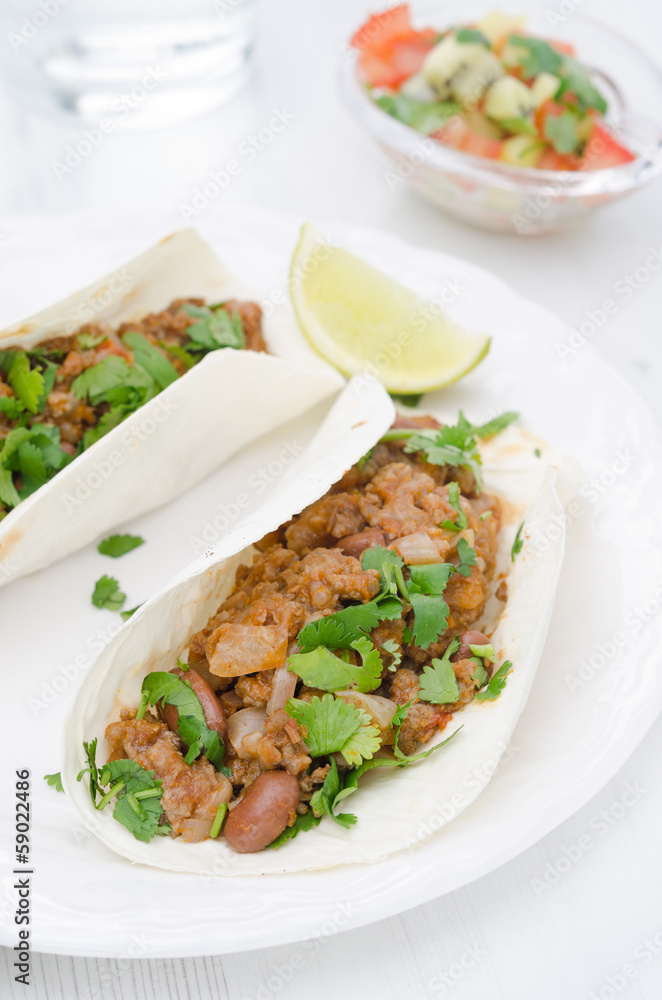 chili con carne in wheat tortillas on a plate and salsa chili con carne in wheat tortillas on a plate and salsa