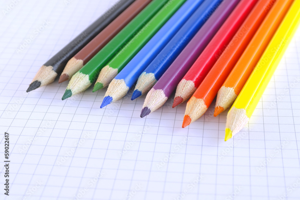 Color pencils on the checked paper of notepad Color pencils on the checked paper of notepad