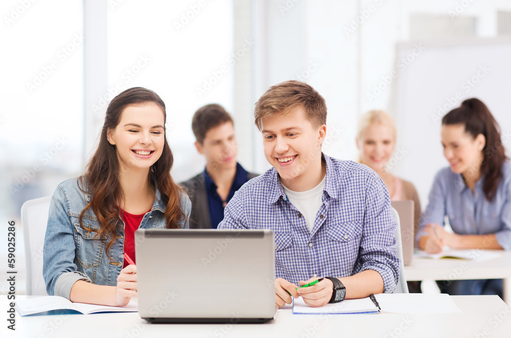 students with laptop and notebooks at school students with laptop and notebooks at school