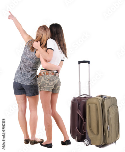 Two young women traveling with suitcas rear view.
