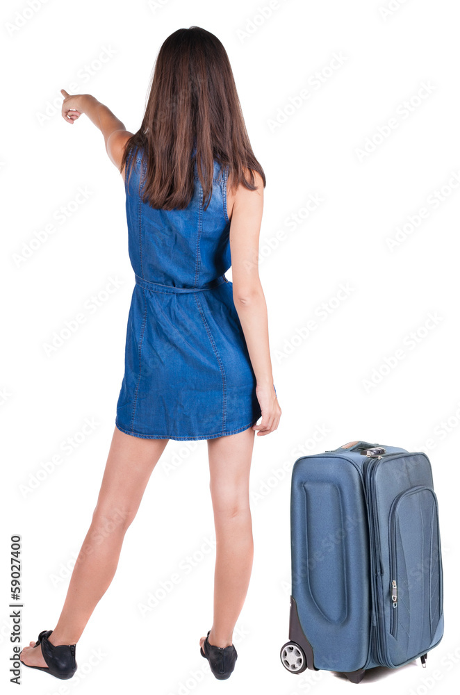 Back view of young brunette woman traveling with suitcas and poi Back view of young brunette woman traveling with suitcas and poi