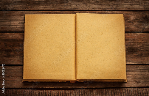 Old blank open book on vintage planked wood table