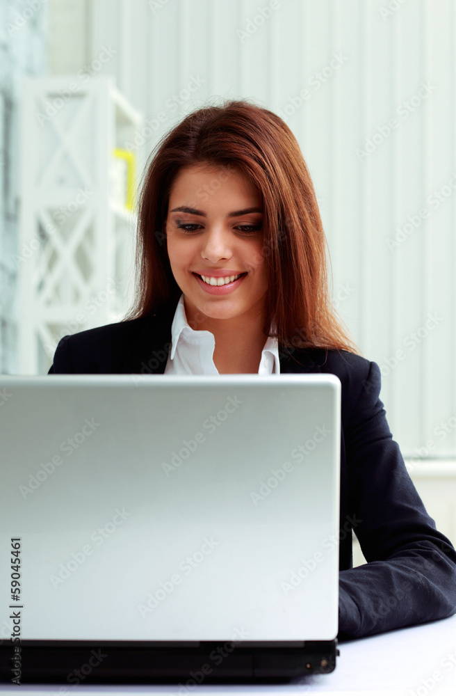 Young cheerful businesswoman working on a laptop in office Young cheerful businesswoman working on a laptop in office