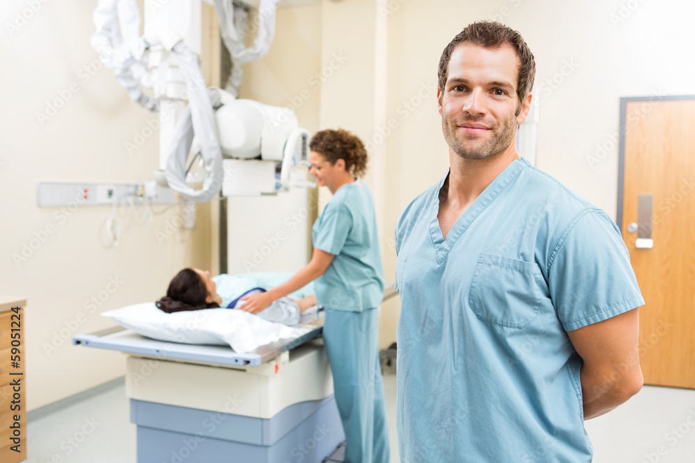 Fototapeta premium Nurse With Colleague Preparing Patient For Xray