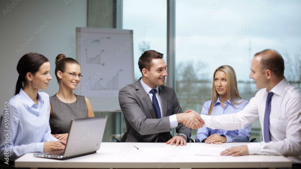 businessmen signing a contract and shaking their hands businessmen signing a contract and shaking their hands