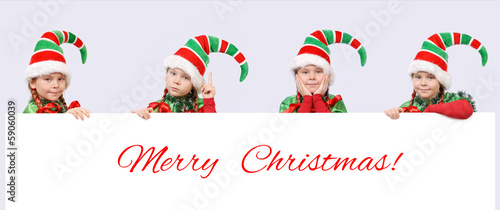 Four girls in suits of Christmas elf with banner
