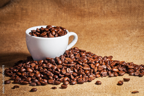 coffee cup and arabica beans on cloth sack