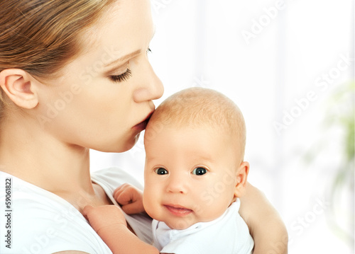 mother kissing newborn baby