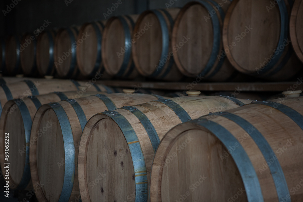 Wine barrels stacked in the cellar of the winery Wine barrels stacked in the cellar of the winery