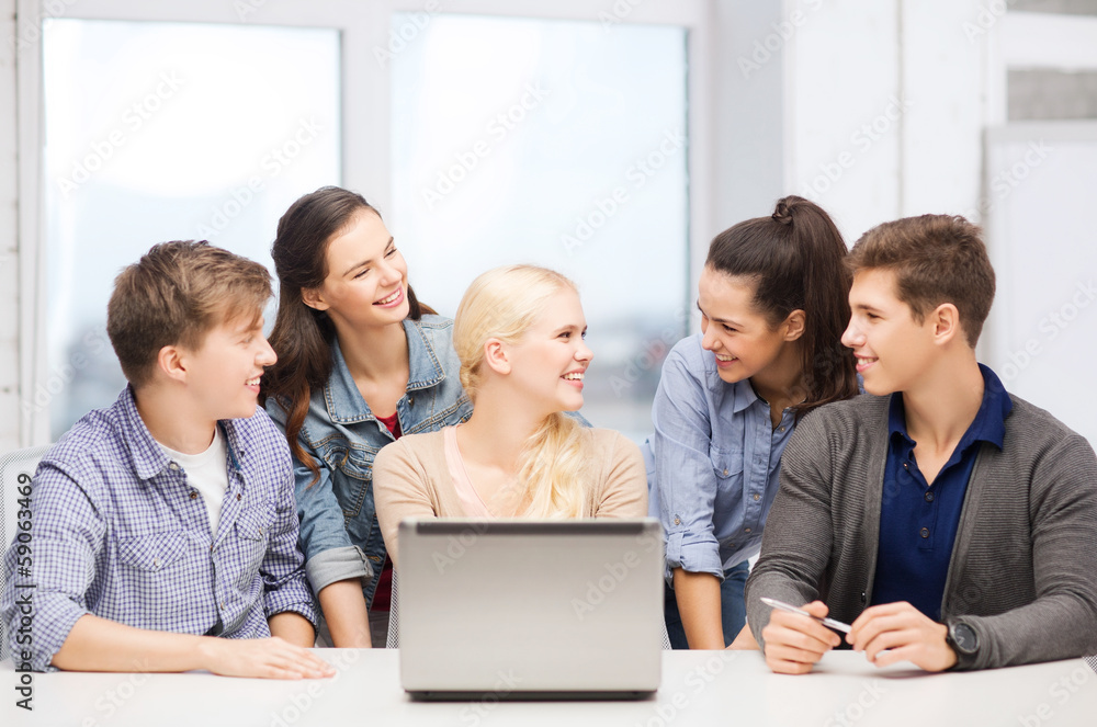 smiling students with laptop at school