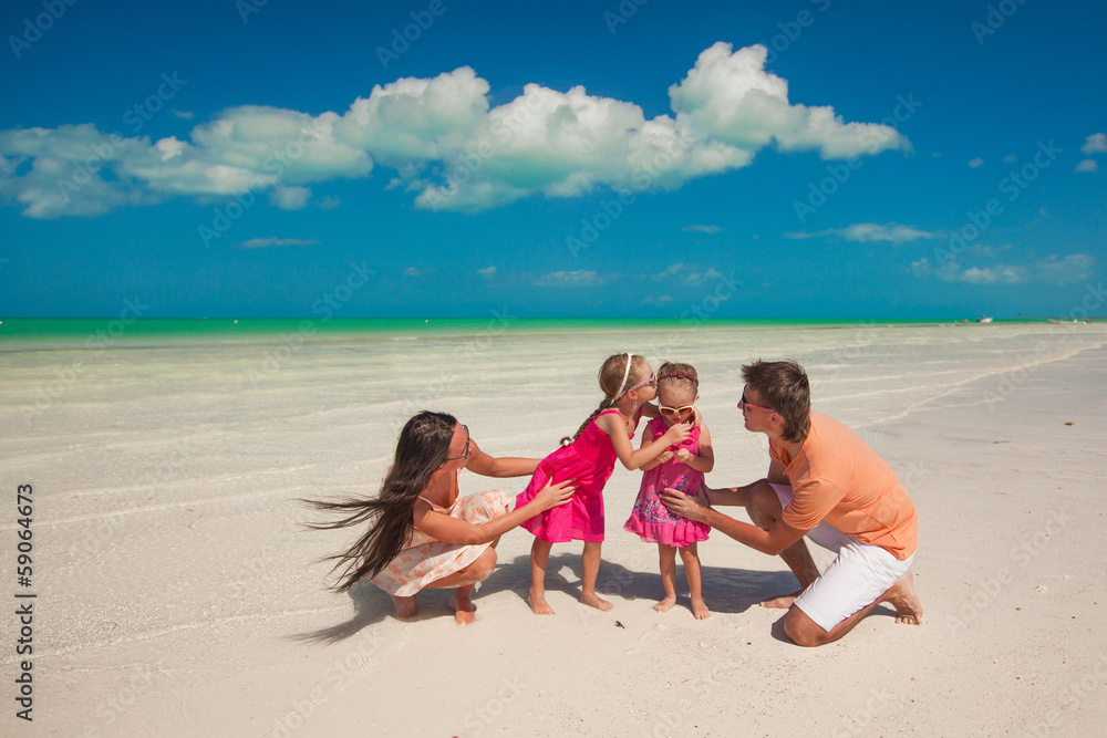 Young beautiful family with two daughters having fun at beach Young beautiful family with two daughters having fun at beach