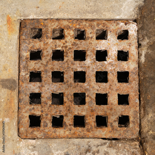 Old and rusty metal sewer lid