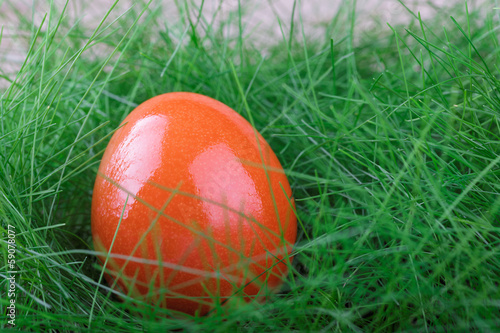 Orange Easter egg on green grass