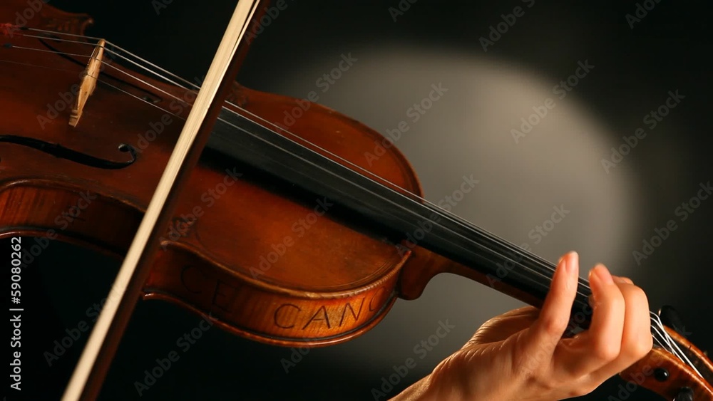 Woman playing violin over dark background Woman playing violin over dark background