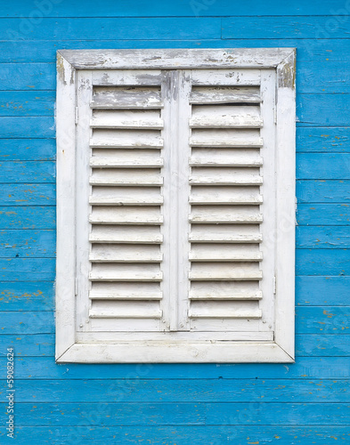 Old white window with wooden shutters.