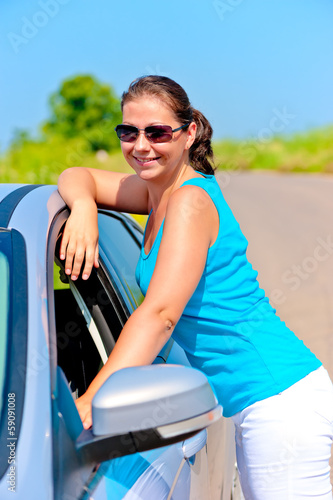 happy girl standing near her car on the road