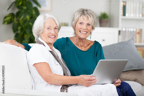 zwei seniorinnen arbeiten am laptop