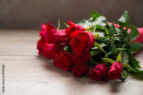Strau   roter Rosen auf Holzuntergrund