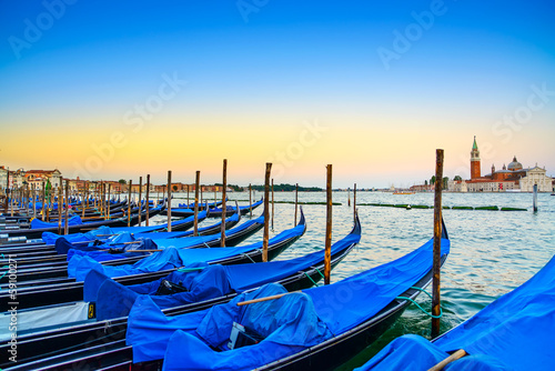 Venice, gondolas or gondole on sunset and church on background. © stevanzz