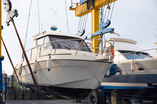 Boat wheel crane elevating motorboat to yearly paint