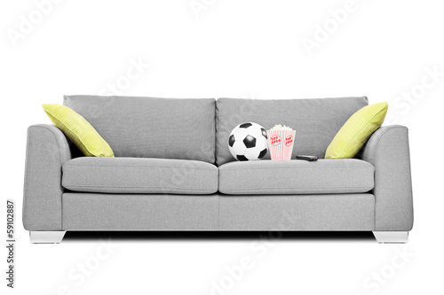 Studio shot of a modern couch with soccer ball and popcorn box © Ljupco Smokovski
