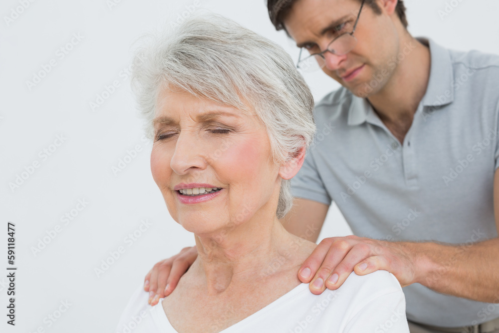 Fototapeta premium Male physiotherapist massaging a senior woman's neck