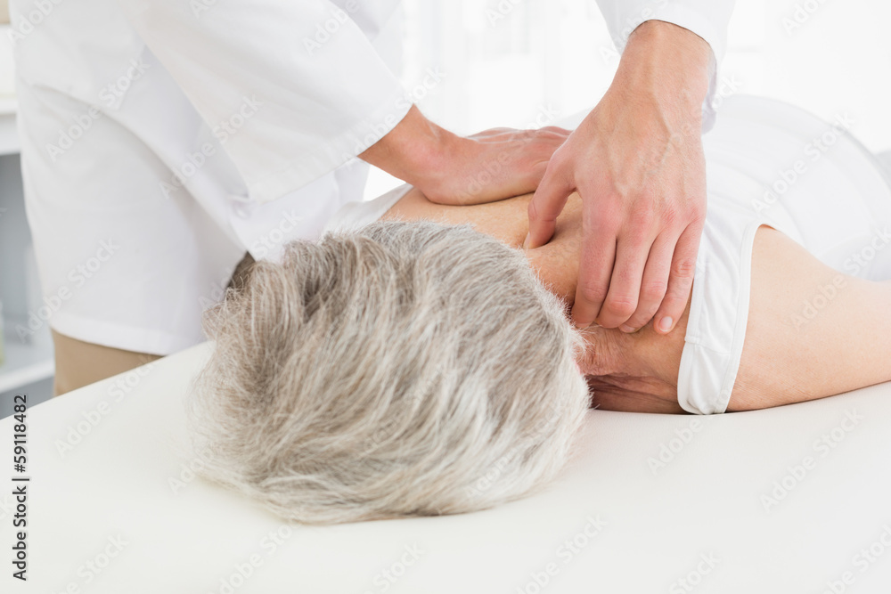 Physiotherapist massaging a senior woman's back Physiotherapist massaging a senior woman's back