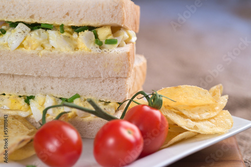 Fresh egg on white sandwich in rustic kitchen setting