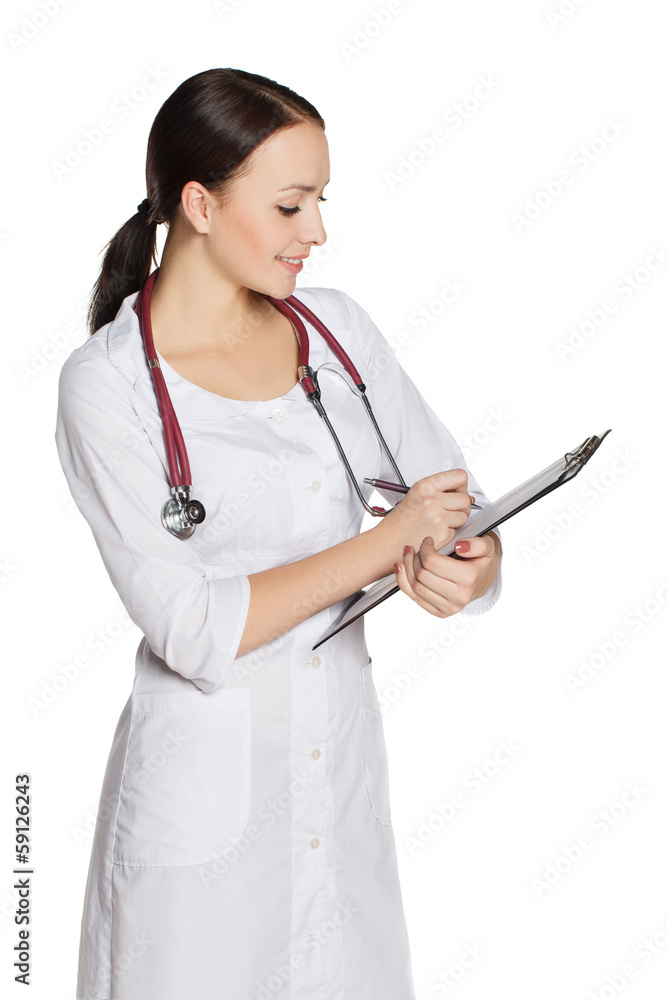 Girl in medical coat with a stethoscope writes on the tablet Girl in medical coat with a stethoscope writes on the tablet