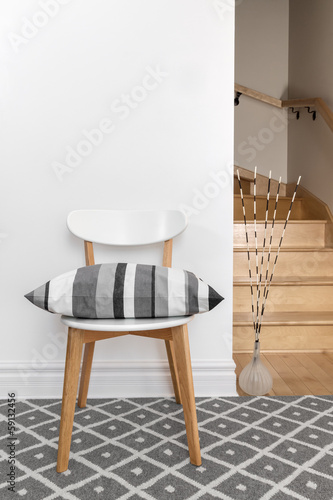 Chair with cushion in a room with staircase