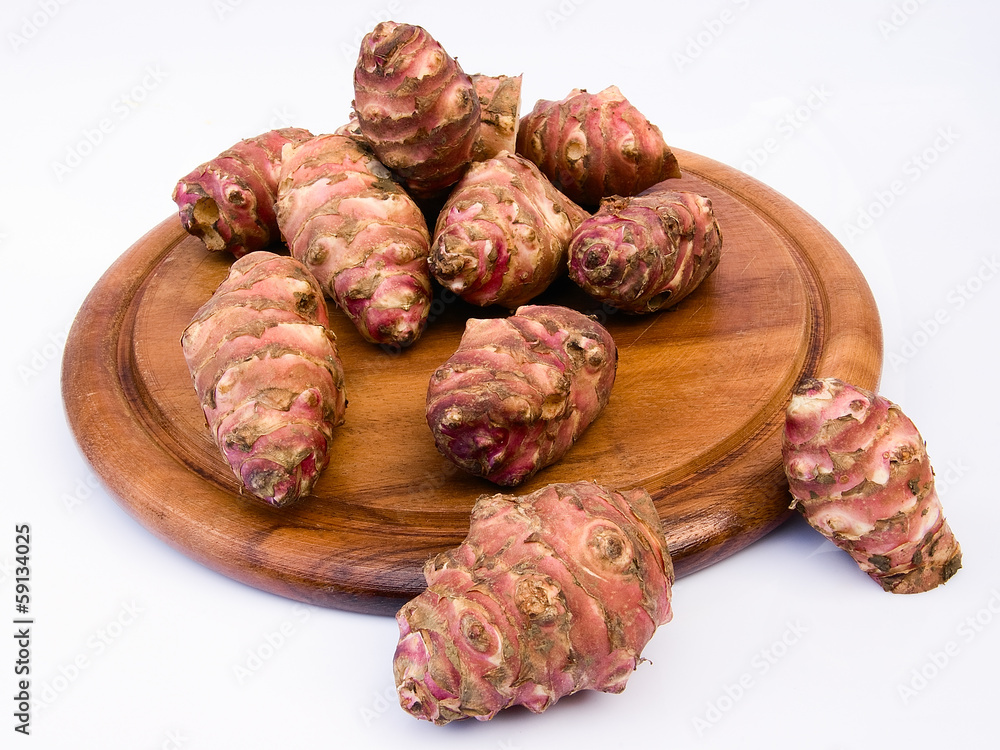 Jerusalem artichoke root on a round board (Helianthus tuberosus Jerusalem artichoke root on a round board (Helianthus tuberosus