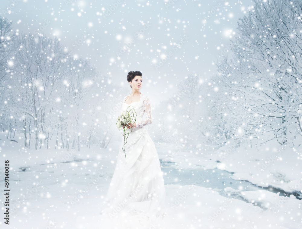 A beautiful bride standing with a flower bouquet on the snow A beautiful bride standing with a flower bouquet on the snow