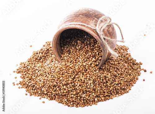 raw buckwheat in bowl isolated on white