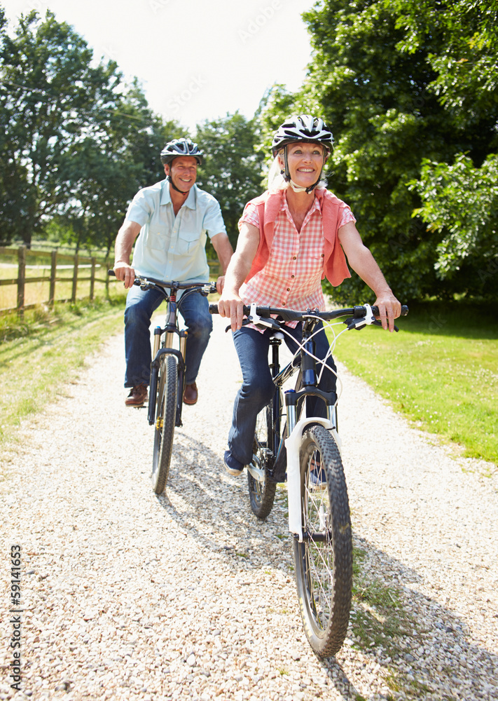 Obraz premium Middle Aged Couple Enjoying Country Cycle Ride Together