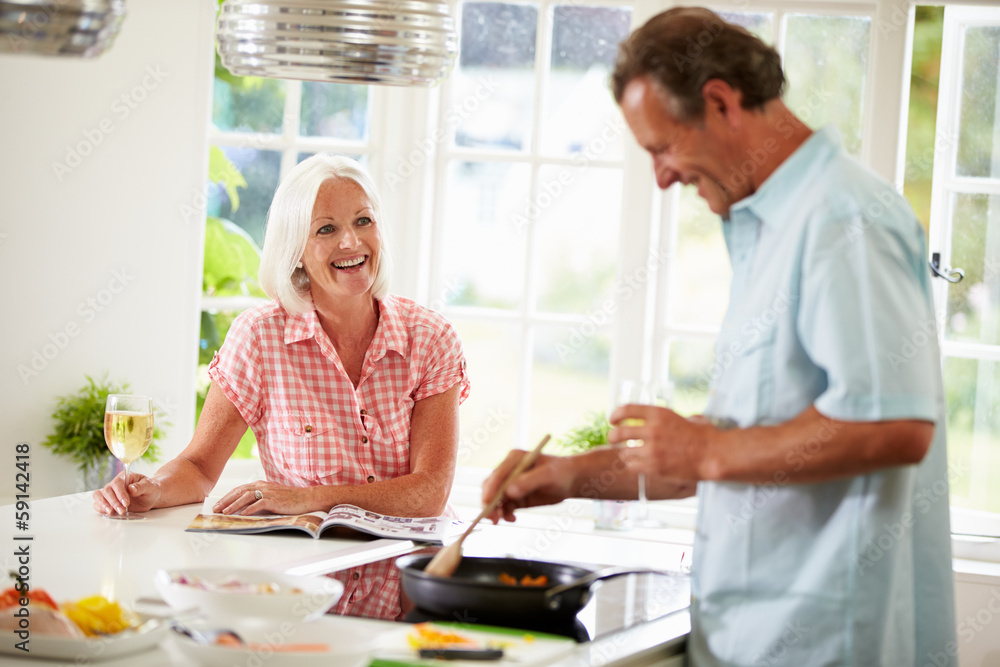 Middle Aged Couple Cooking Meal In Kitchen Together Middle Aged Couple Cooking Meal In Kitchen Together