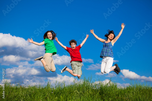 Active family - mother and kids running  jumping outdoor