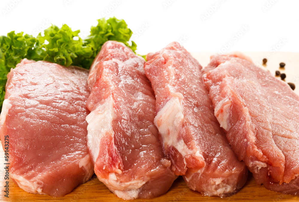 Raw pork on cutting board and vegetables Raw pork on cutting board and vegetables