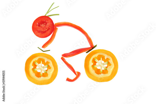 Healthy eating. Funny little man of the pepper slices on a bicyc photo