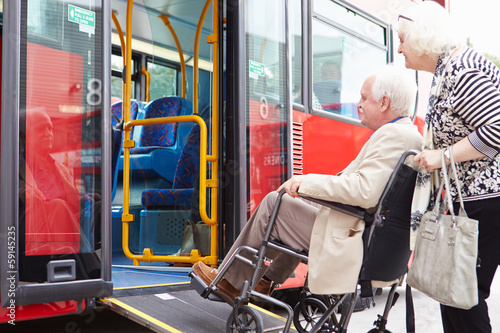 Senior Couple Boarding Bus Using Wheelchair Access Ramp