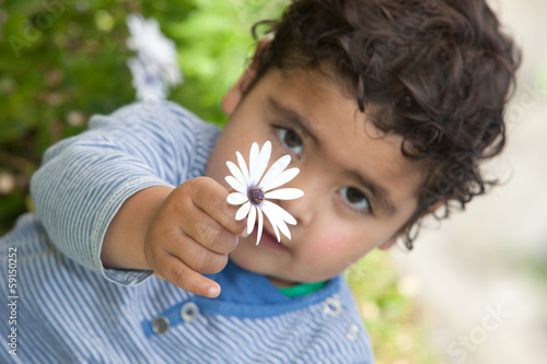 little boy holding a flower