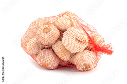 Garlic in a net over white background