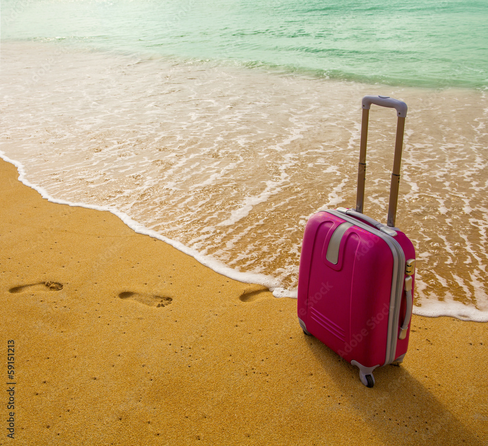 Suitcase on the beach with white sand