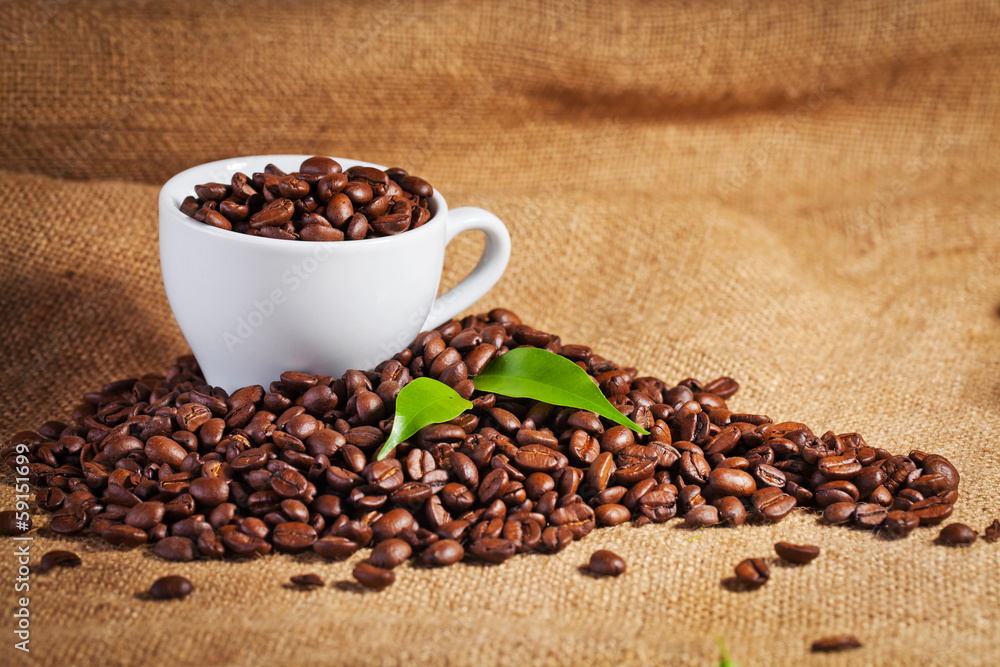 Fototapeta premium coffee cup and arabica beans on cloth sack