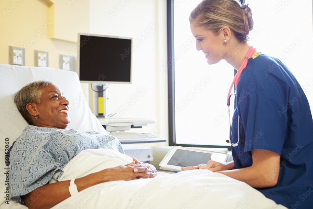 Obraz premium Nurse With Digital Tablet Talks To Woman In Hospital Bed
