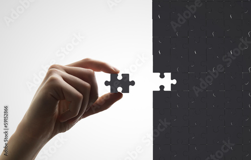 hand puts puzzle