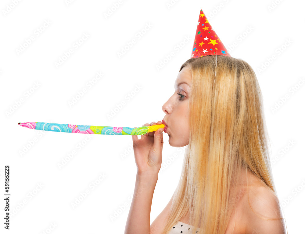 Profile portrait of girl in cap blowing in party horn blower Stock ...