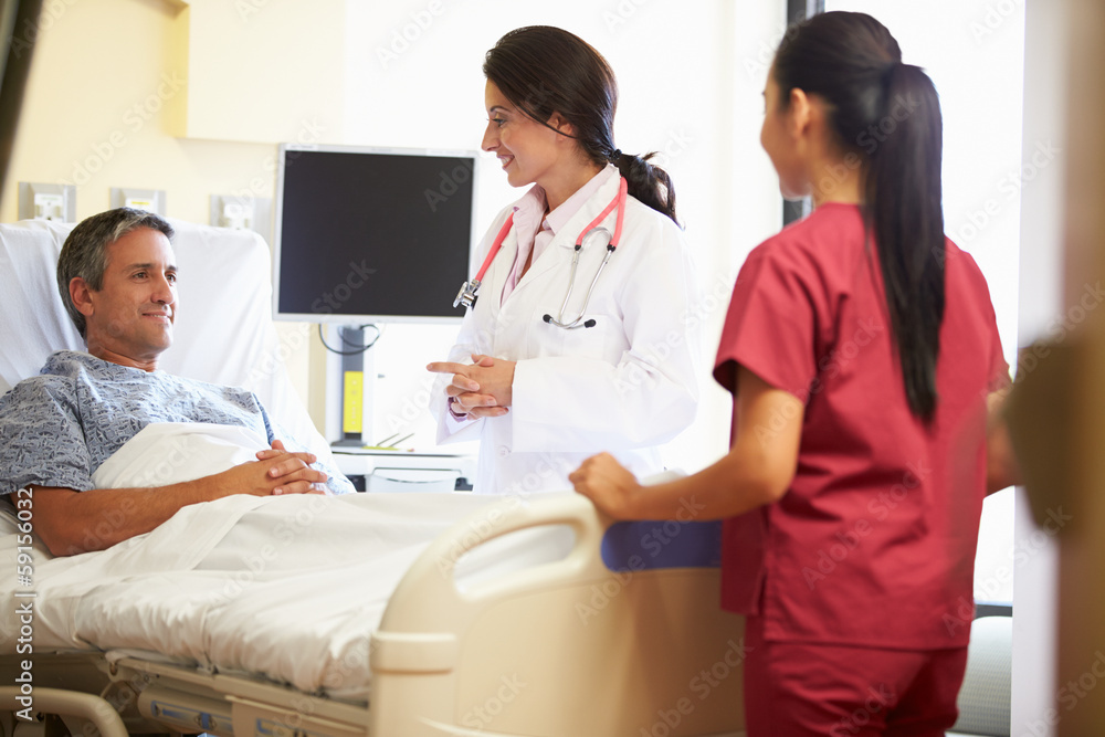 Female Doctor Talking To Male Patient In Hospital Room Female Doctor Talking To Male Patient In Hospital Room