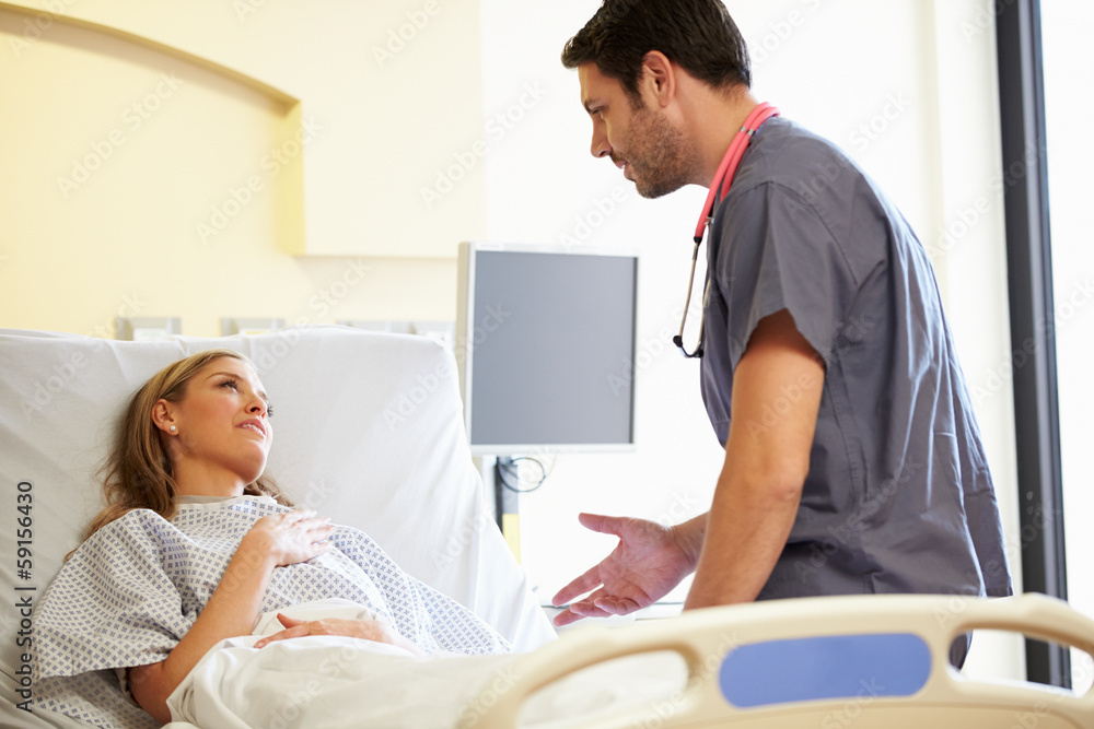 Fototapeta premium Male Nurse Talking With Female Patient In Hospital Room